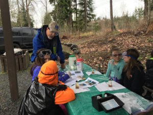 Nisqually Stream Steward volunteer Roger Andrascik helps students monitor water quality with the Nisqually River Education Project. 